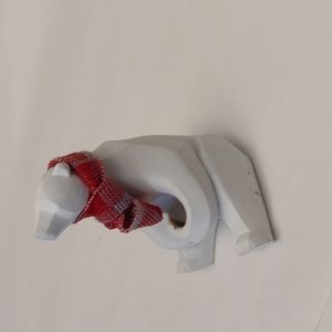 White wooden polar bear figuring with red plaid scarf